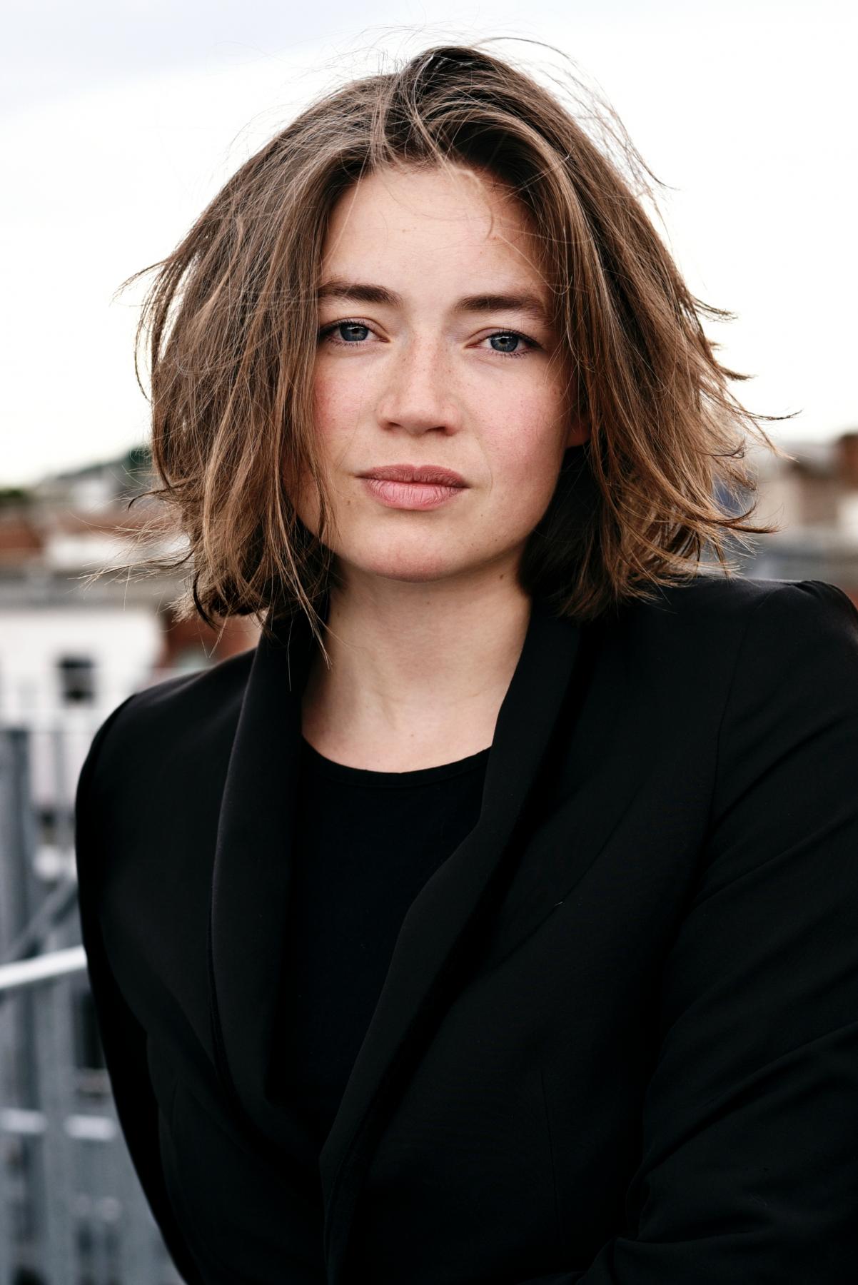 Portrait einer jungen Frau mit kurzem, braunen Haar.