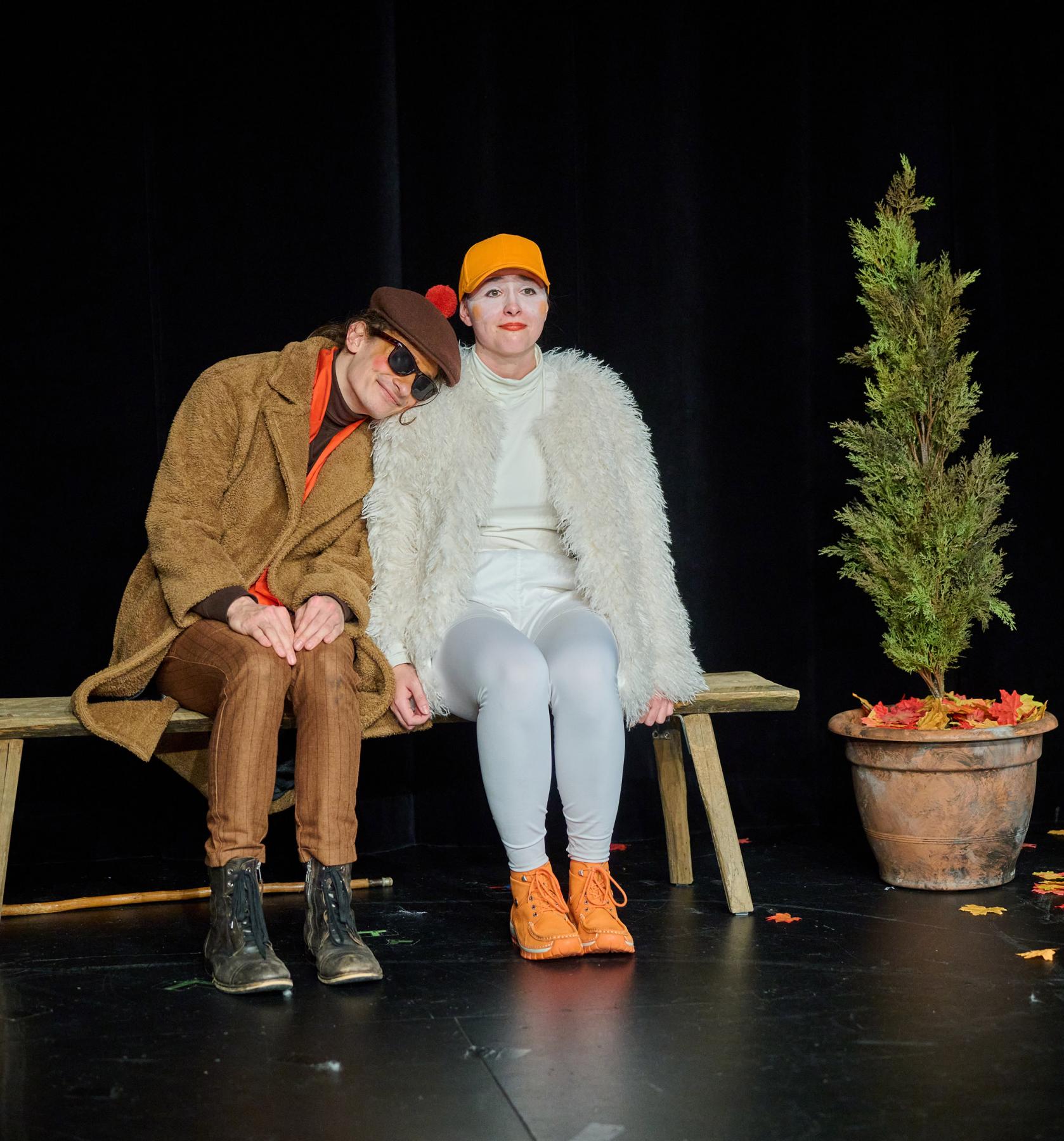 Szenenfoto aus LAHME ENTE, BLINDES HUHN: Ente und Huhn sitzen auf einer Bank, Huhn lehnt den Kopf an die Schulter der Ente.