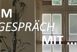 Ein Bild von einer weißen Wand mit einem großen Fenster darin, vor der Wand steht eine Grünpflanze, ein weißer Schriftzug davor "IM GESPRÄCH MIT ..."