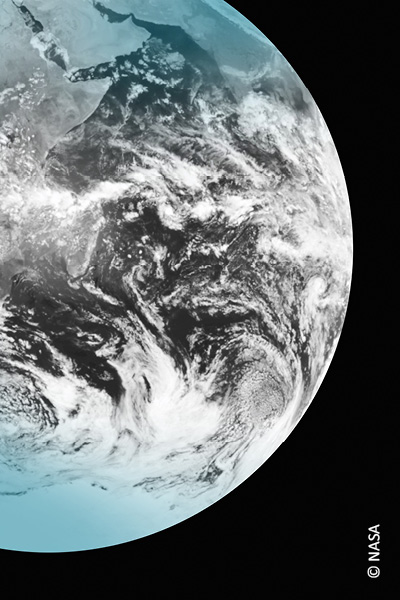 Satellitenaufnahme der Erde aus dem All, die Erde ist schwarz-weiß und nur am oberen sowie unteren Rand türkis eingefärbt